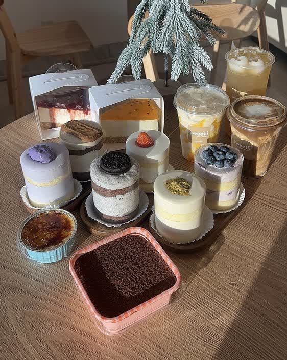 A spread of Sweetii's mini mousse cakes, creme brulee, and tiramisu, boxed and ready to take home